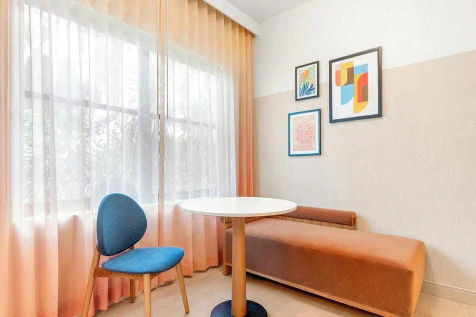 Sip morning coffee at the intimate table beside glowing curtains.