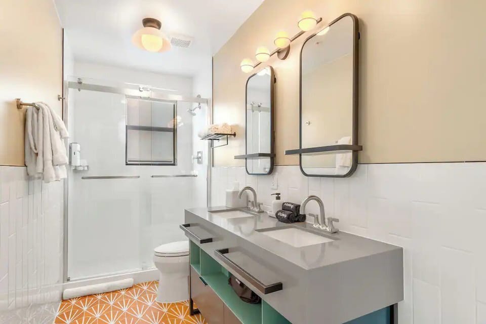 Refresh in a spotless bath with double vanity and bright lighting.