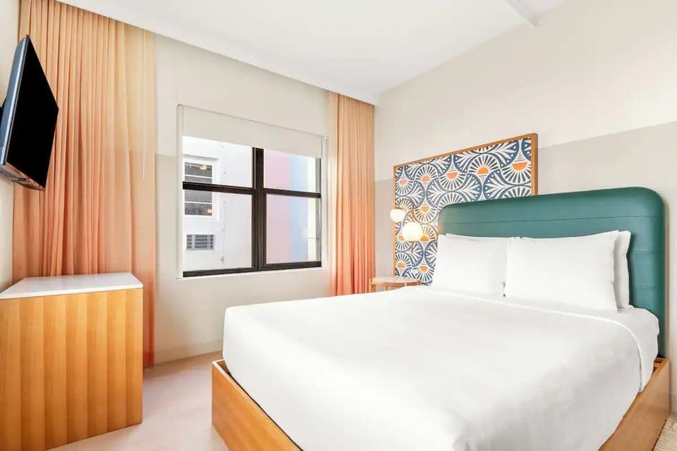 Unwind in a sunlit bedroom with crisp linens and calm.