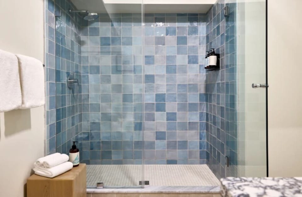Refresh under a spacious rainfall-style shower with spa-like tiles.