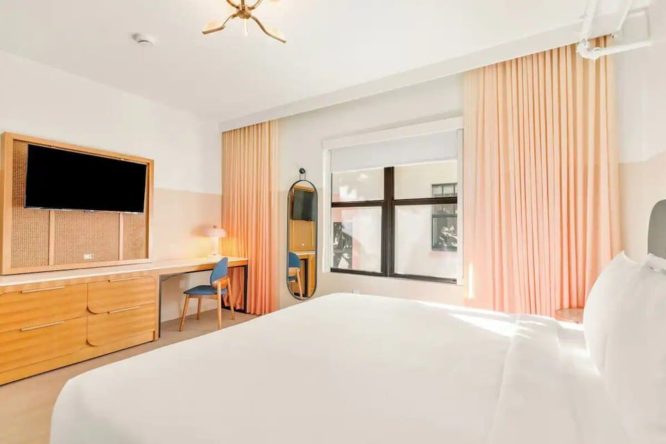Wake up gently in a bright room with soft drapes.