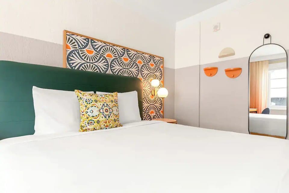 Drift off beneath statement wall art and plush linens.