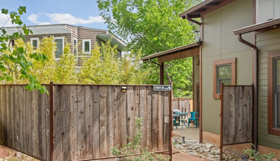 Private fenced entry with a stone pathway leads to your own covered patio. The gate is marked 1501-B for easy arrival.