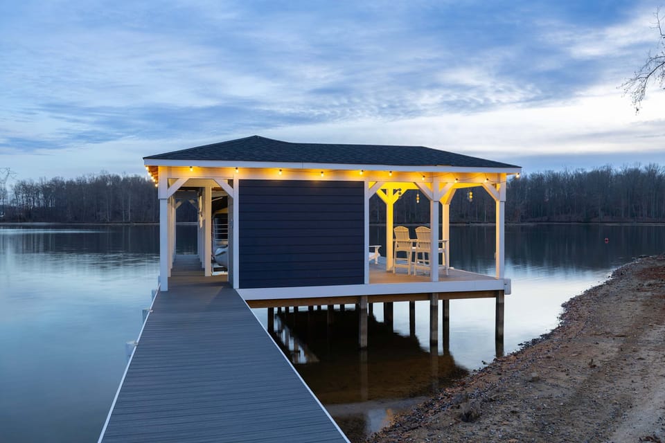 Boathouse - The boathouse lit up at dusk, its white structure perfectly reflected in the calm dark water.