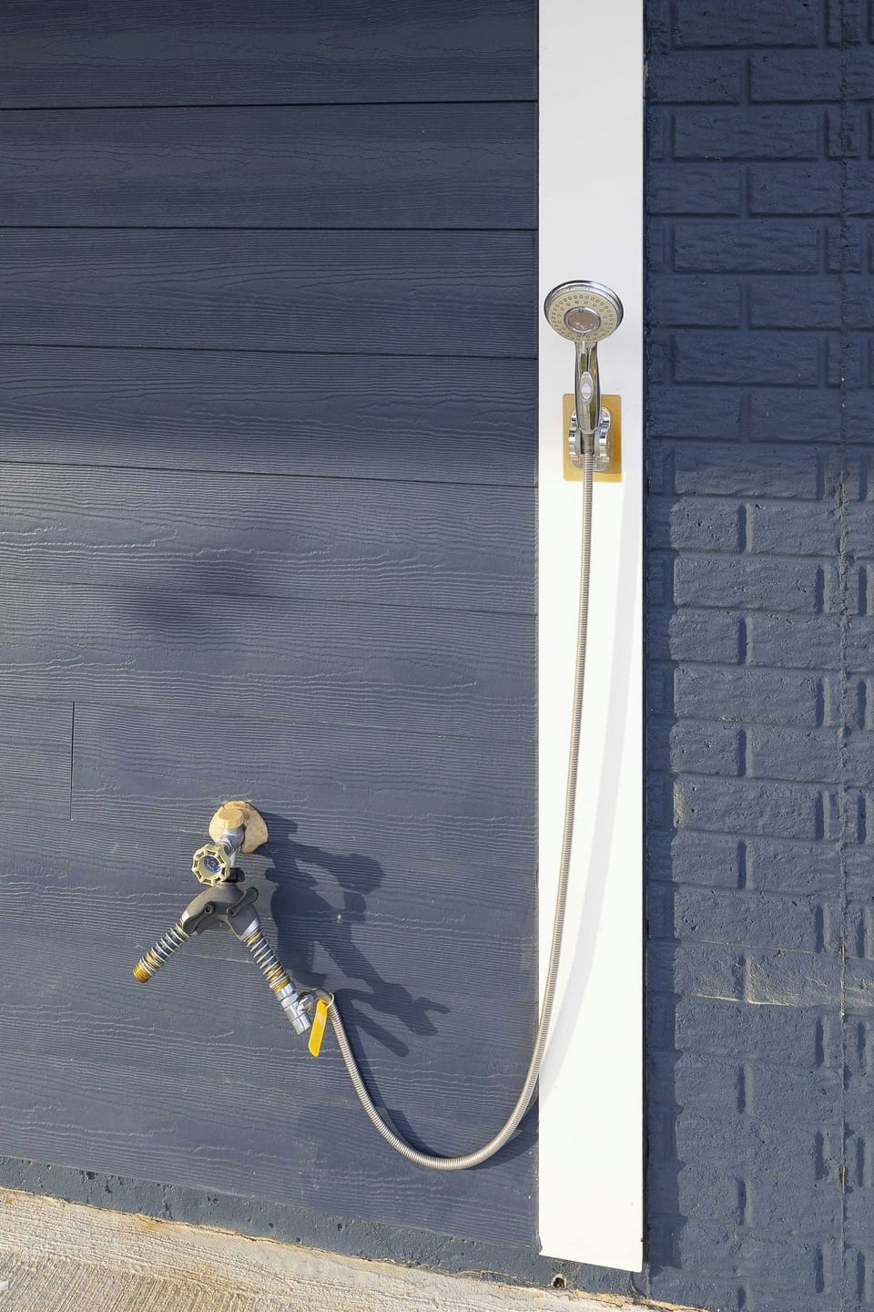 Exterior - An exterior hose bib on the side of the house, convenient for rinsing gear, kayaks, and wet swimwear after a lake day.