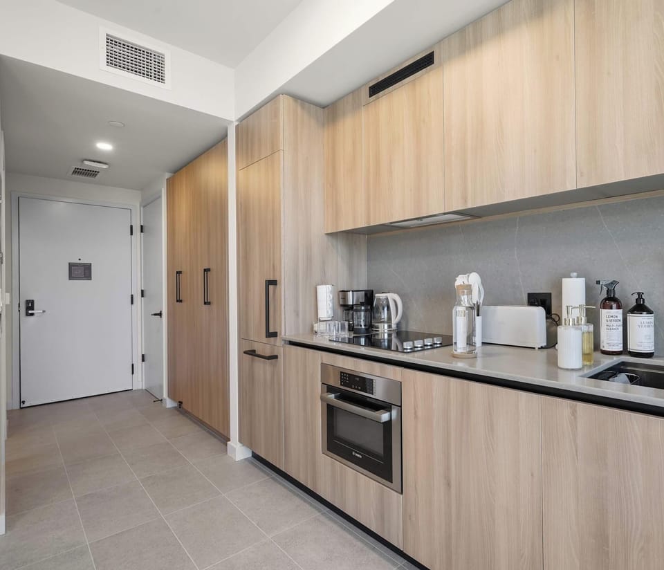Sleek full kitchen with modern appliances and wood cabinetry