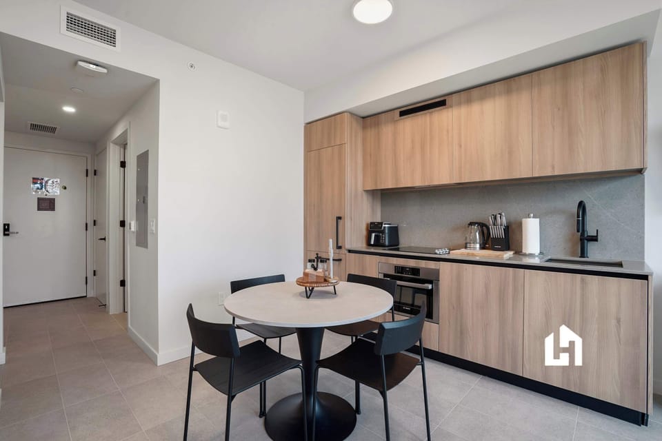 Fully equipped kitchen with sleek cabinetry and a cozy dining table perfect for meals or morning coffee.