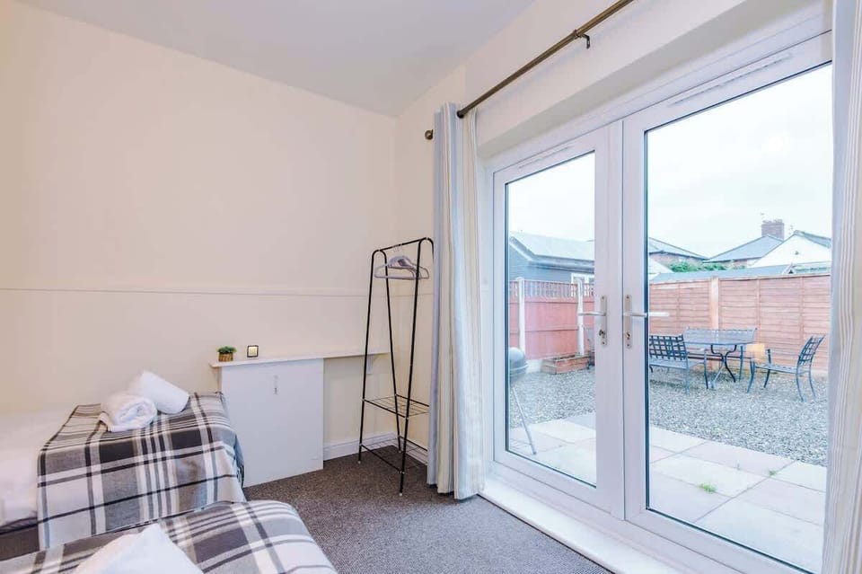 Charming bedroom with two single beds that convert to a double, stylish blue accents, and cozy touches for a relaxing stay.