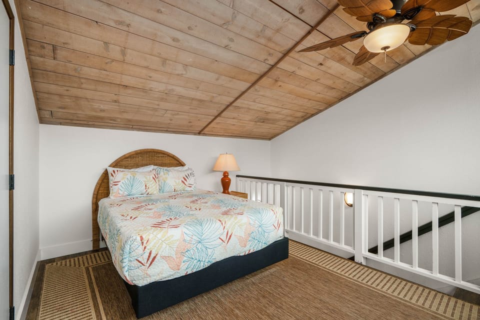 Charming loft bedroom with warm wood ceilings and a cozy, private feel