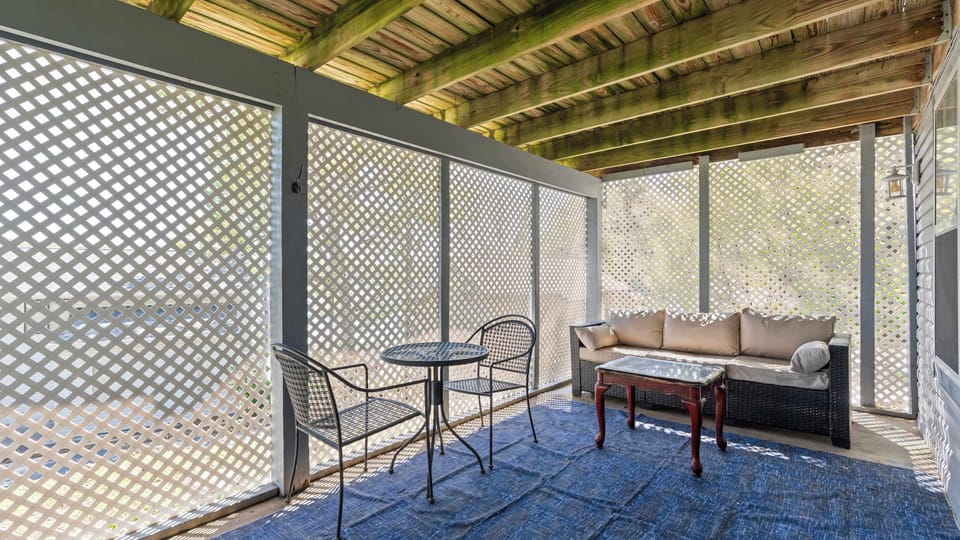 Covered patio with seating area and hot tub 