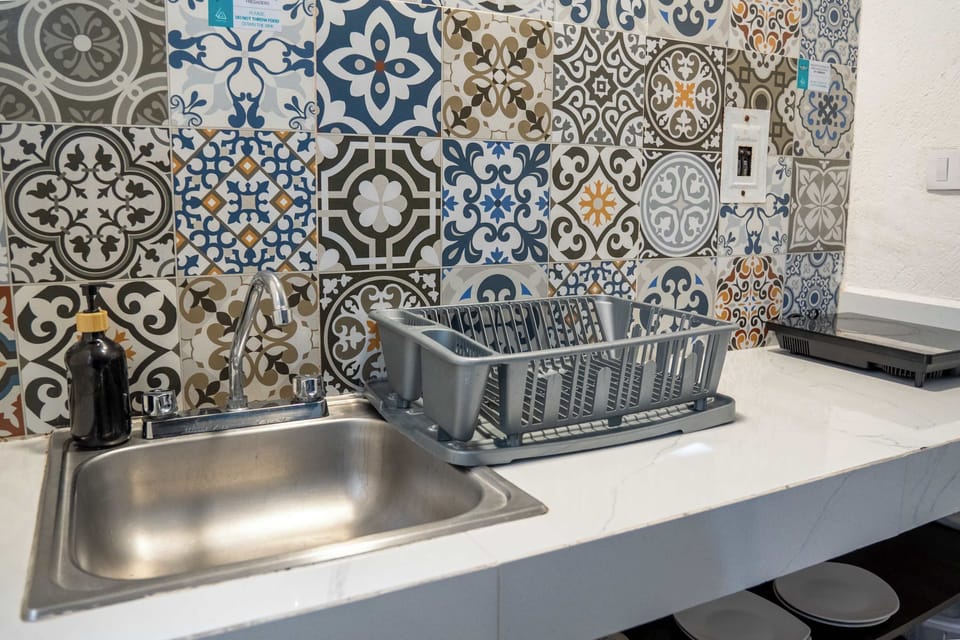 Fully equipped kitchenette with a vibrant patterned backsplash and full sink, everything you need to cook in