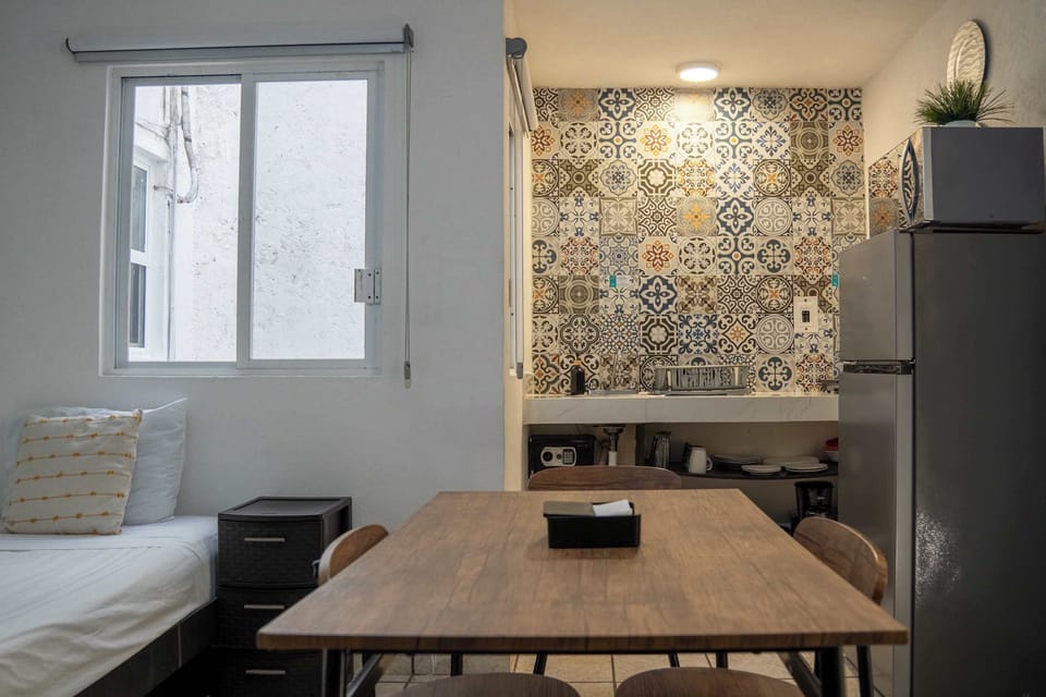 Sunny dining nook with patterned tile and a full fridge, ready for relaxed home-style meals