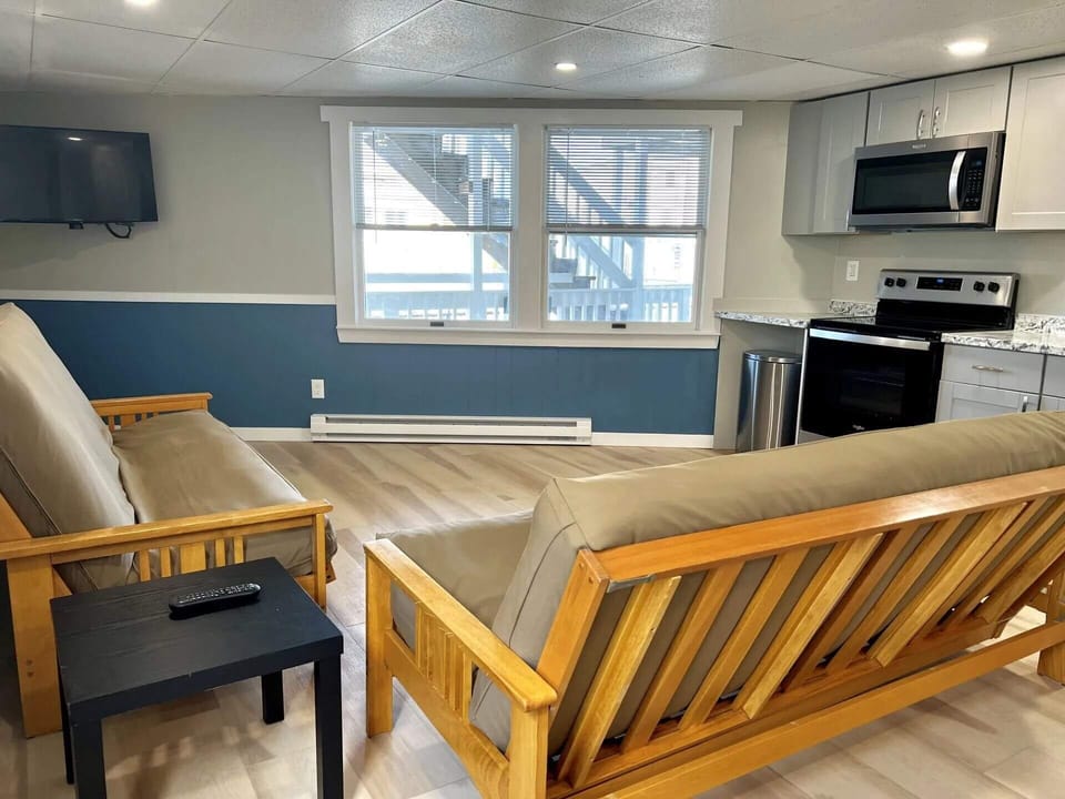 The open living room/kitchen space has two full sized futons as well as a full kitchen with range, microwave, fridge, etc. Picture is likeness only.