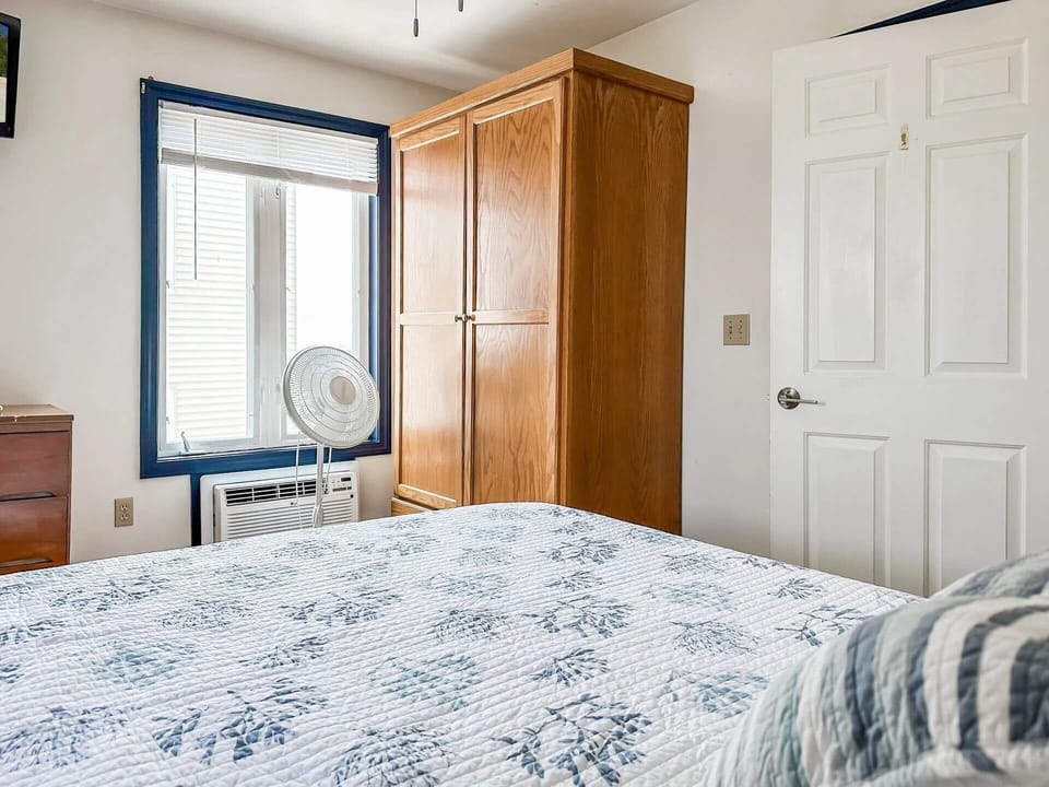 Bedroom with queen bed and AC unit. Picture is likeness only.