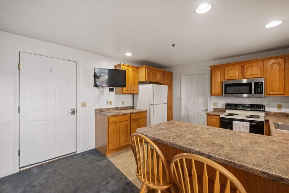 Full kitchen with breakfast bar provides plenty of space for cooking and eating.