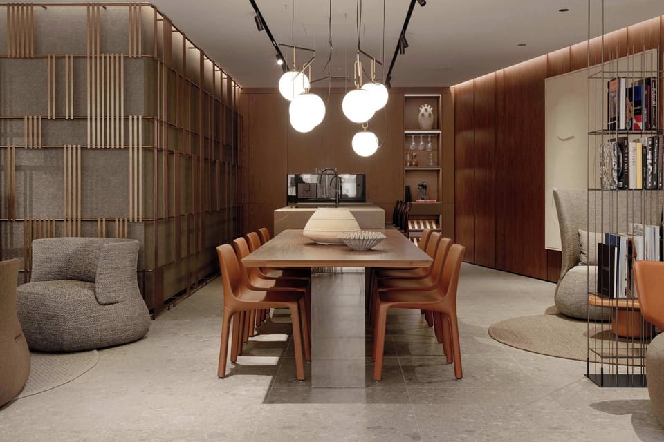 A sophisticated dining room centered around a long wooden table surrounded by matching contemporary chairs. Spherical pendant lights hang above the table, casting light across rich wood panelling and plush armchairs in the corners.