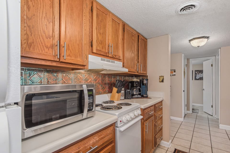 Cook your favorite meals in this fully equipped kitchen with warm wood cabinets, modern appliances, and everything you need for a comfortable stay.