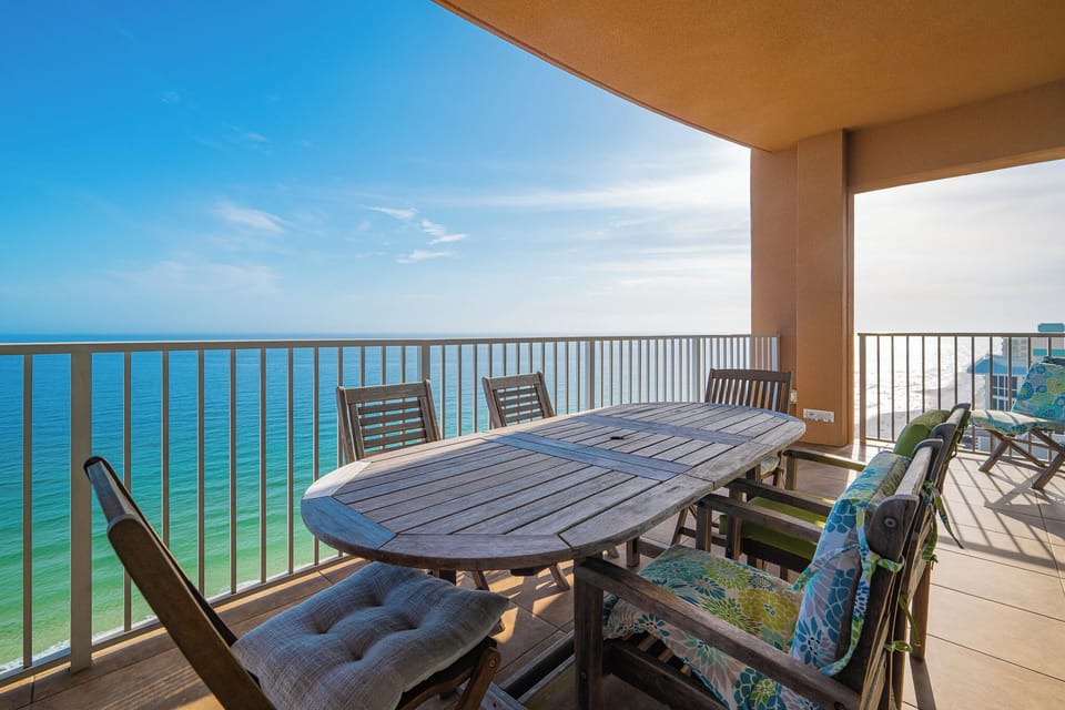 Wooden chairs frame a large table where you gather for refreshing drinks while watching the turquoise coast