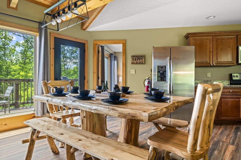 Gather family and friends around the handcrafted log dining table in the bright open-concept dining area, just steps from the fully equipped kitchen and mountain-view deck.