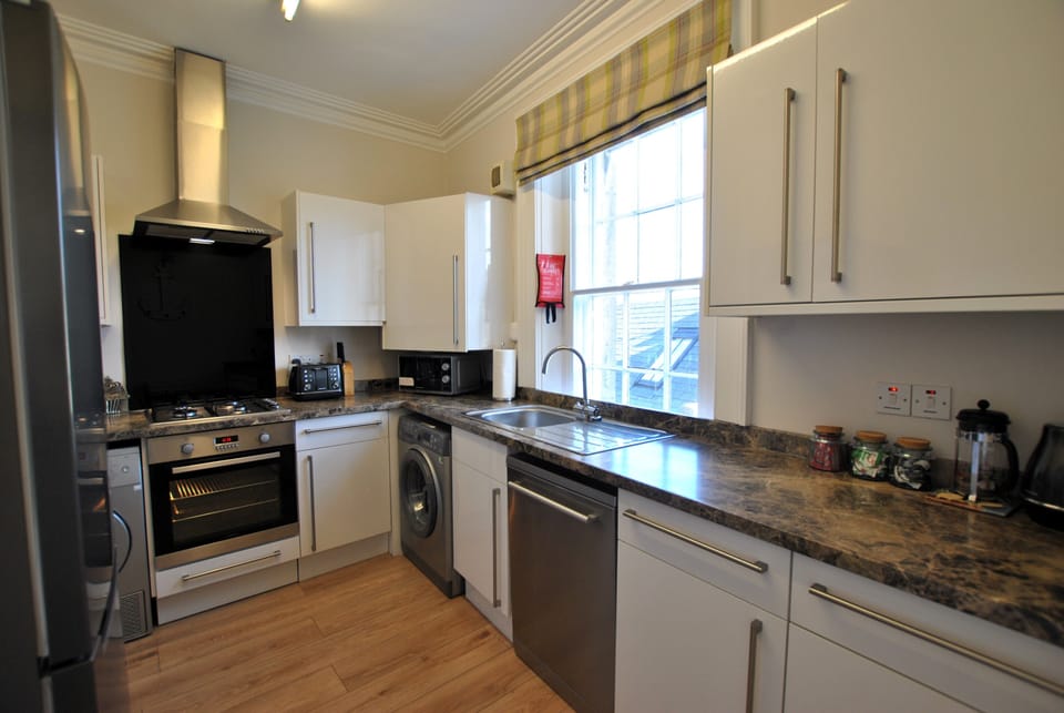 The kitchen has a washing machine and tumble dryer