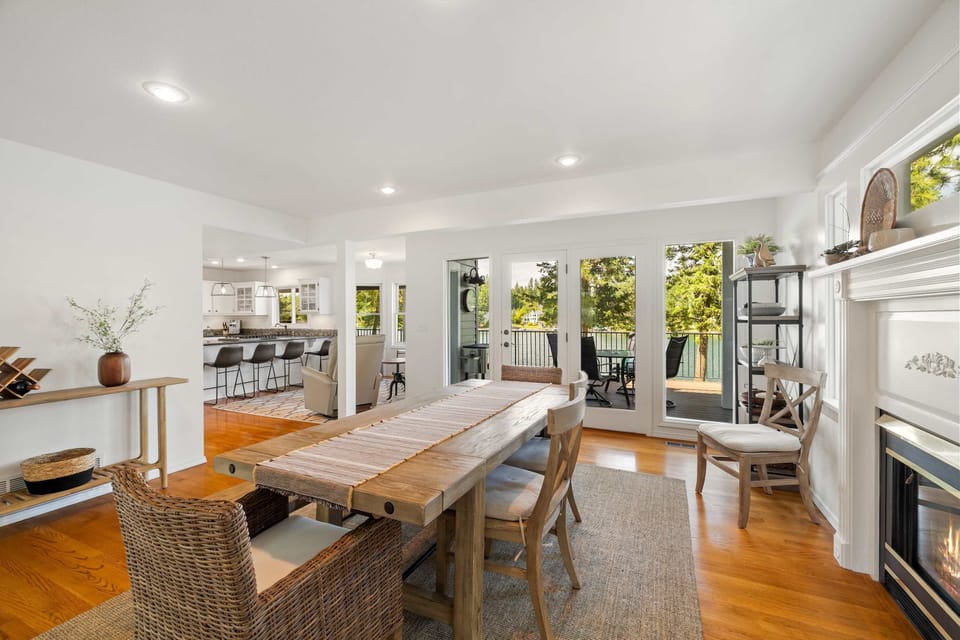 Eating area with large dining table, gas fireplace and access to the back deck overlooking the Spokane River