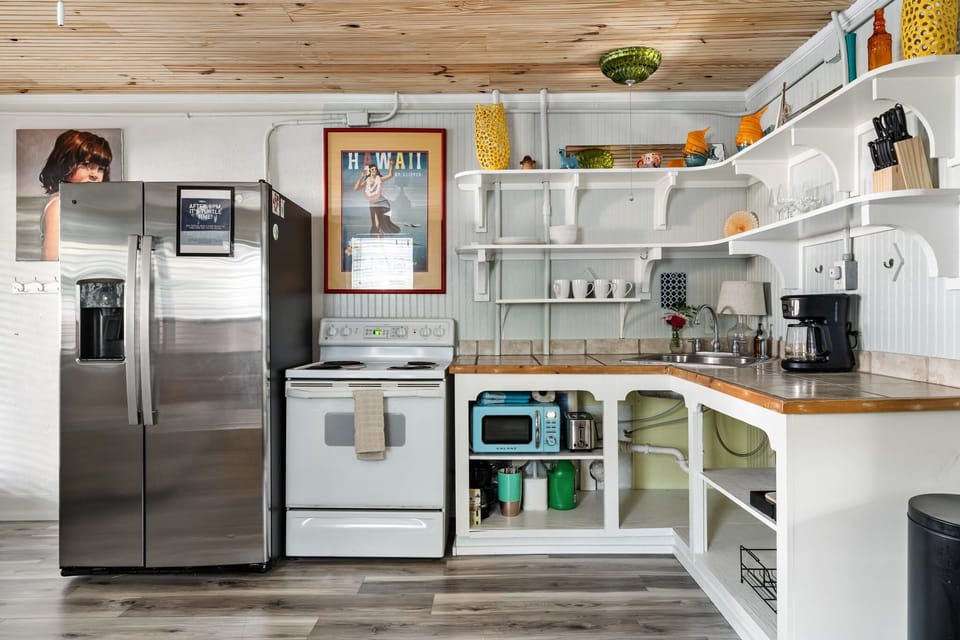 Cook with ease in the fully equipped kitchen featuring a full size refrigerator, stove, oven, microwave, dishwasher, coffee maker, toaster, blender, and all the cooking essentials.
