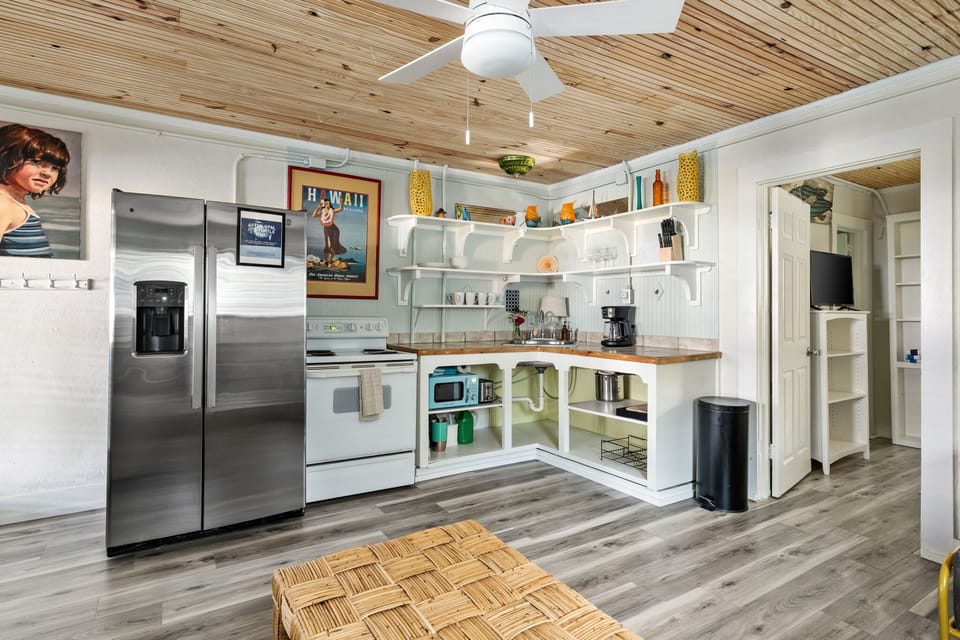 Cook with ease in the fully equipped kitchen featuring a full size refrigerator, stove, oven, microwave, dishwasher, coffee maker, toaster, blender, and all the cooking essentials.