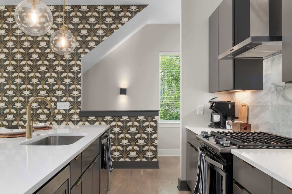 Full cooking setup with a gas range, stainless steel range hood, and quartz countertops 