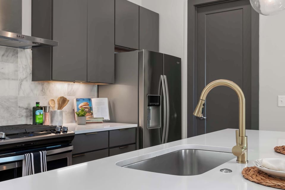 A deep undermount sink with a brass pull-down faucet
