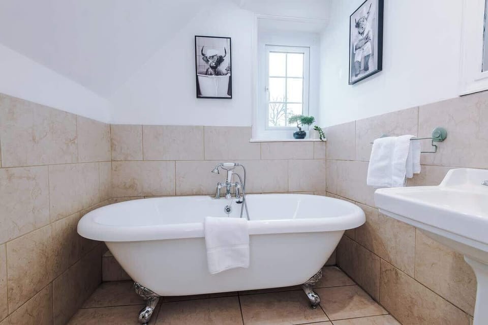 A clean bathroom with a toilet seat, a sink, and a bathtub for relaxing baths.