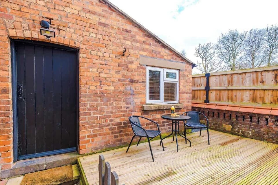 A small backyard with a table and two chairs, offering a peaceful outdoor space. There is open back space with fresh air, perfect for relaxing or enjoying a quiet moment outside