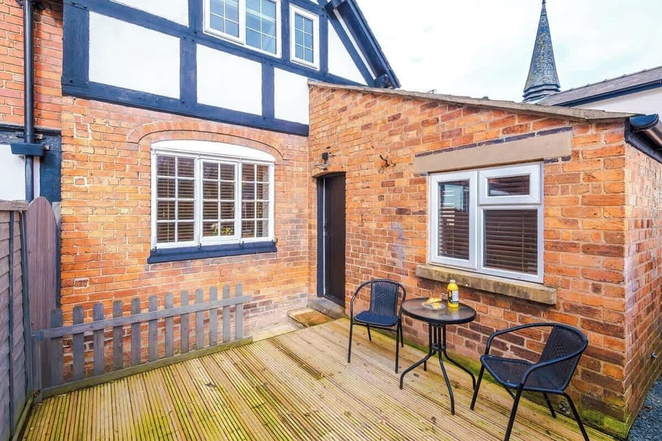 A small backyard with a table and two chairs, offering a peaceful outdoor space. There is open back space with fresh air, perfect for relaxing or enjoying a quiet moment outside