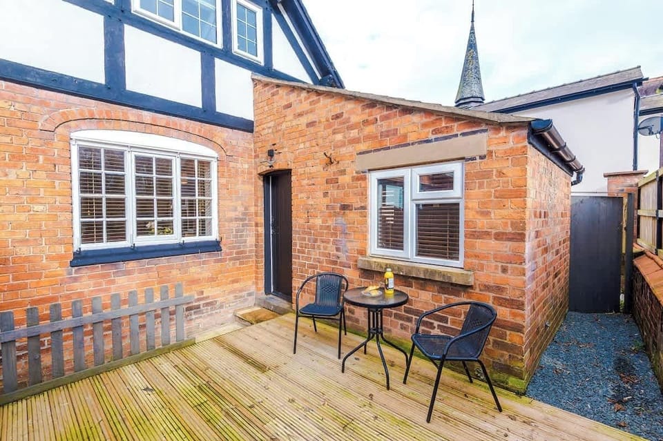 A small backyard with a table and two chairs, offering a peaceful outdoor space. There is open back space with fresh air, perfect for relaxing or enjoying a quiet moment outside