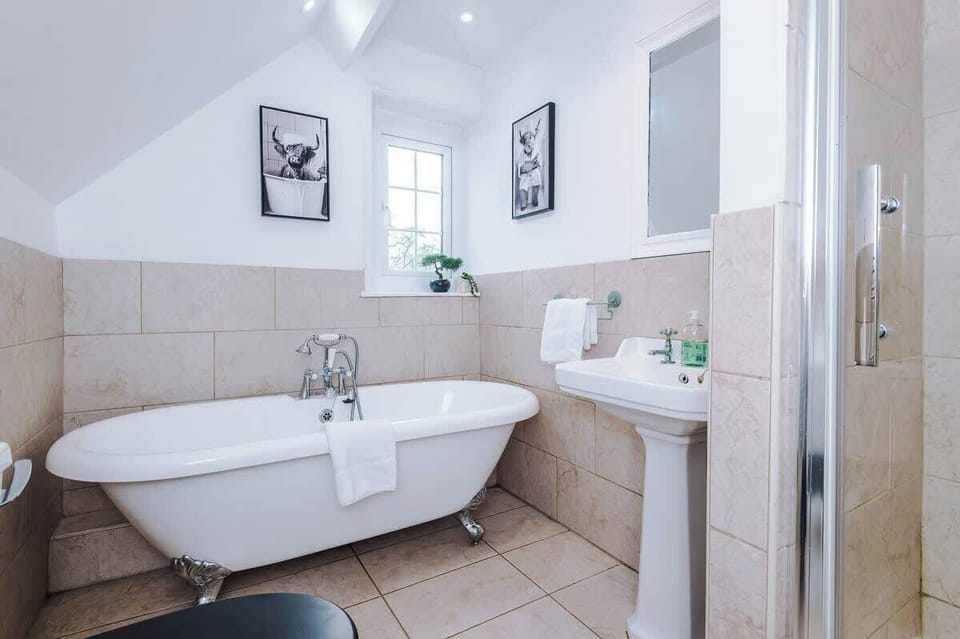 A clean bathroom with a toilet seat, a sink, and a bathtub for relaxing baths.