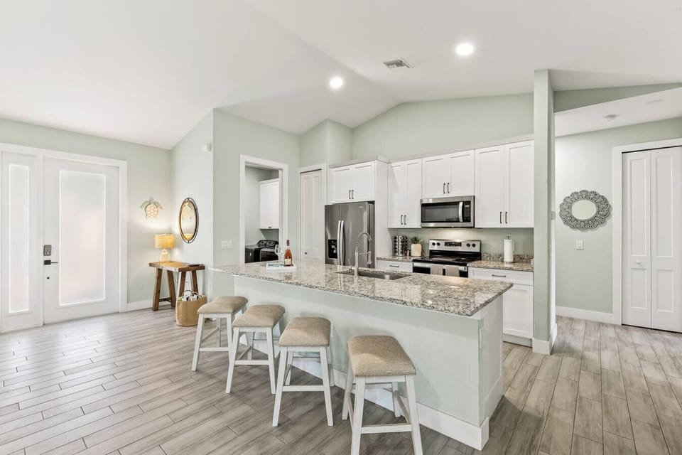 Fully equipped kitchen with granite counters, bar seating, and stainless appliances