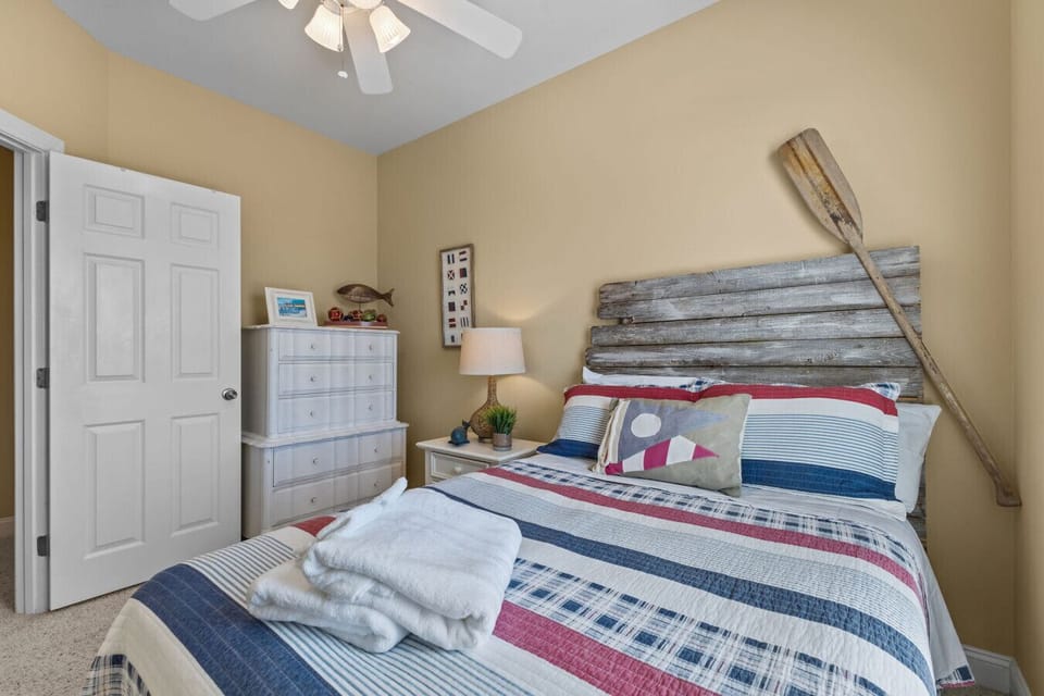 Guest Bedroom 3 with cozy full bed, dresser, ceiling fan, and coastal decor at Marsh House in Atlantic Beach