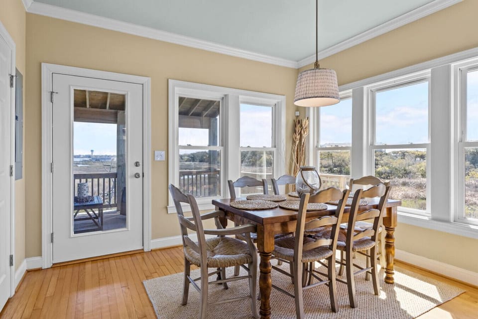 Sunlit dining space with beautiful views and access to outdoor deck at Marsh House, Atlantic Beach