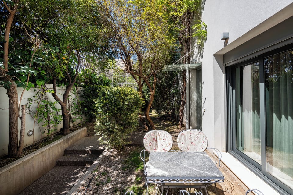 Cosy patio surrounded by lush greenery for serene outdoor relaxation.