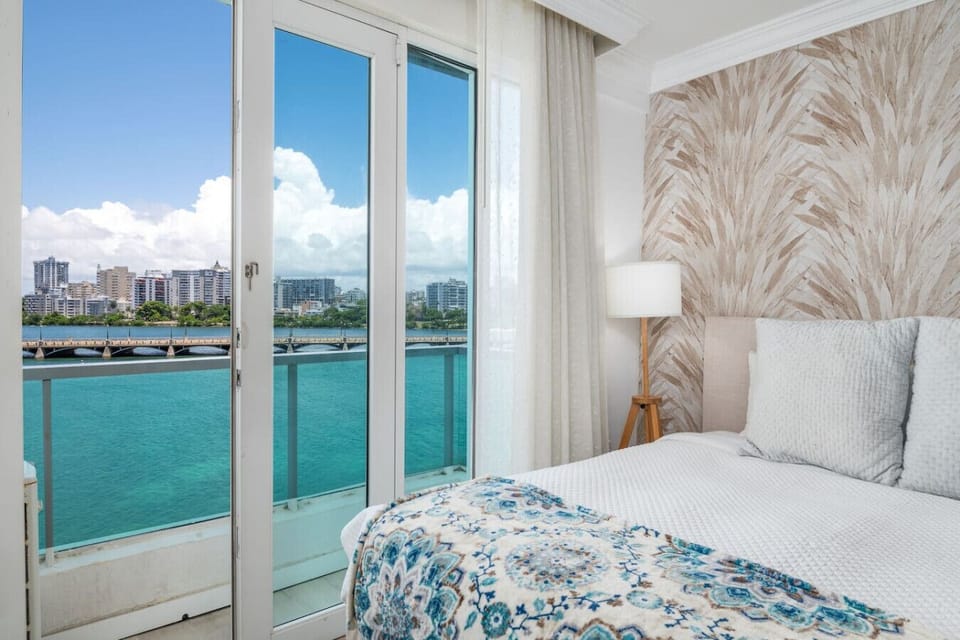 Relaxing bedroom with TV and direct access to ocean-view balcony.