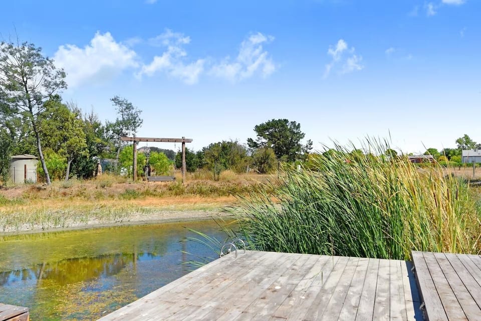 The pond offers a tranquil setting with a swing, perfect for enjoying the scenic views and the serene atmosphere of the property.