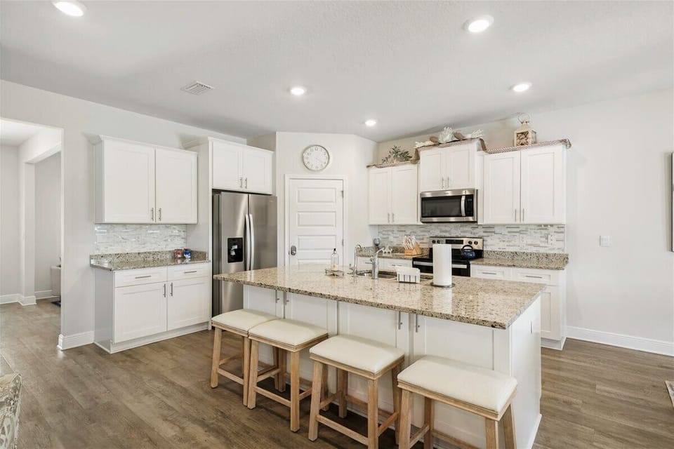 Full kitchen—fully stocked with stainless steel appliances and a kitchen island with seating for 4 bar stools.