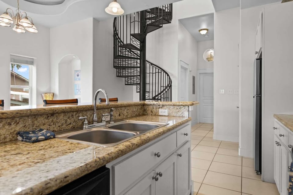 A full kitchen with granite counters and plenty of prep space