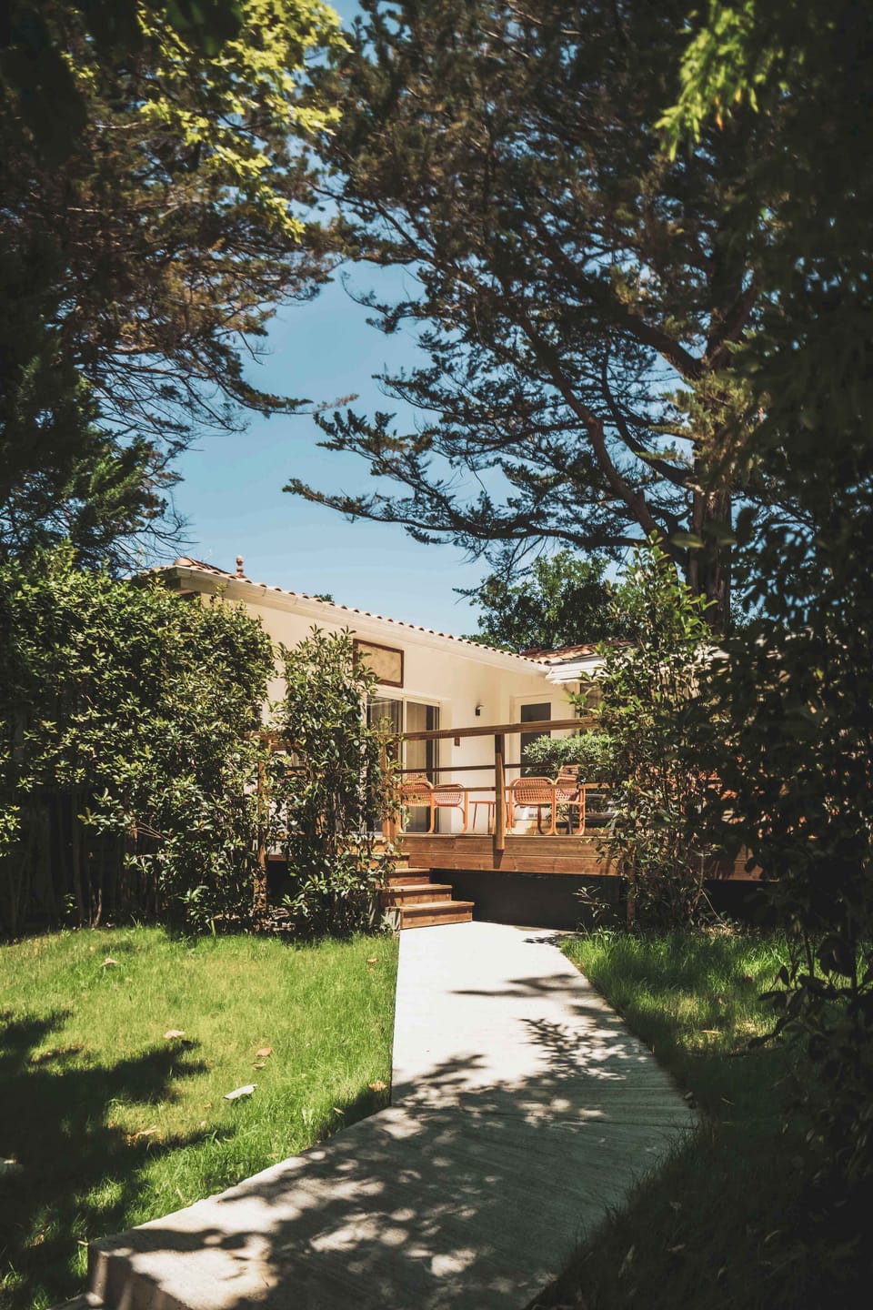 Surrounded by lush greenery, the apartment opens onto a peaceful garden path — a quiet escape just steps from the sea.