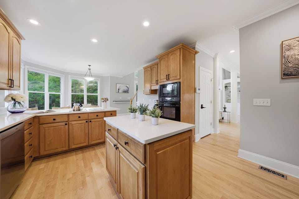 Bright modern kitchen with warm wood cabinetry and sleek stainless‑steel appliances.