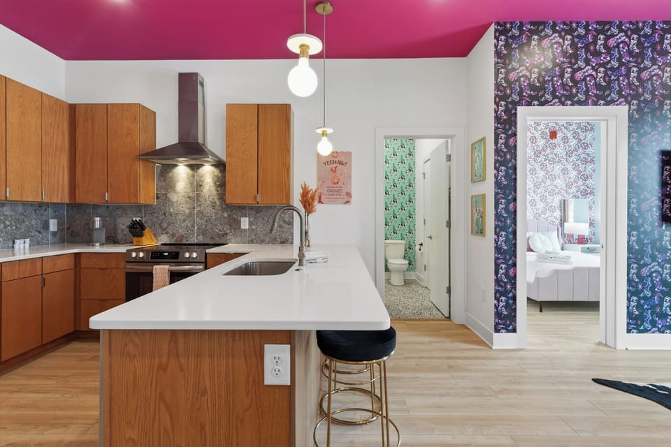 Unit 102: A stylish kitchen with bar seating, stainless steel appliances, and playful design touches.