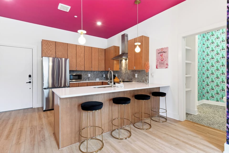 Unit 102: A stylish kitchen with bar seating, stainless steel appliances, and playful design touches.