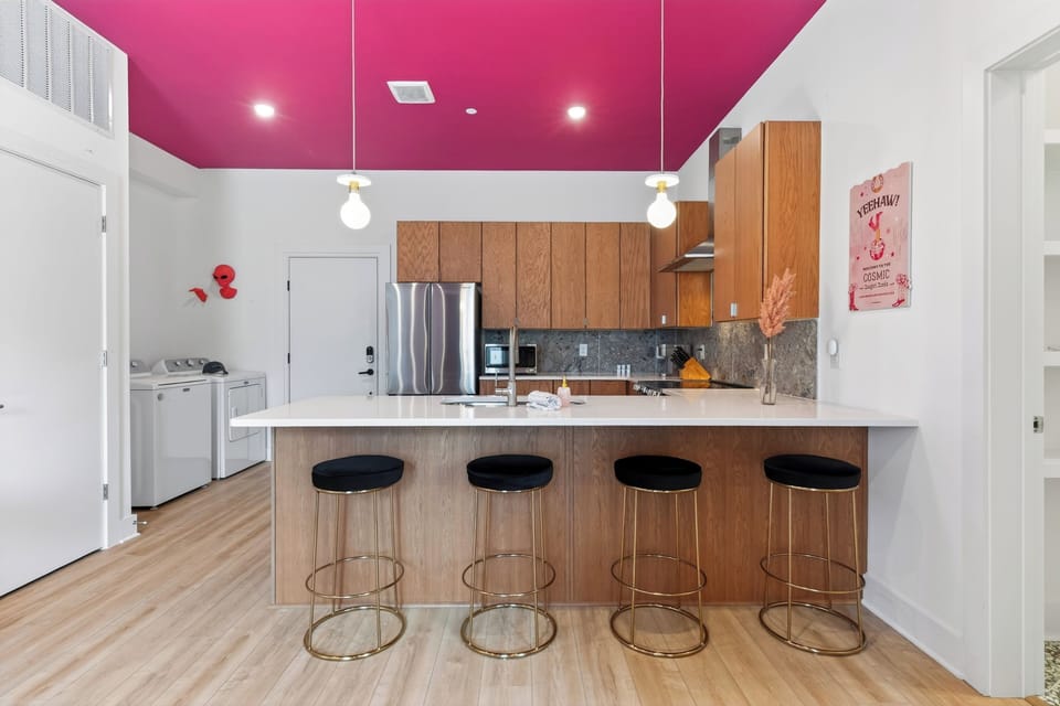 Unit 102: A stylish kitchen with bar seating, stainless steel appliances, and playful design touches.