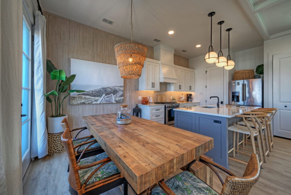 Bright coastal kitchen and dining area with warm textures and a relaxed island vibe.