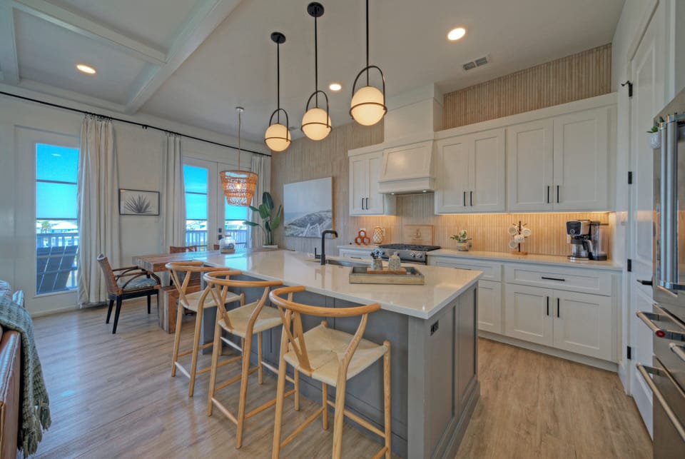 Modern coastal kitchen and dining area with warm wood accents and airy natural light.