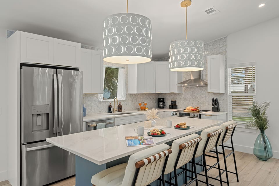Bright modern kitchen with a marble island, warm wood accents, and a clean, inviting layout.